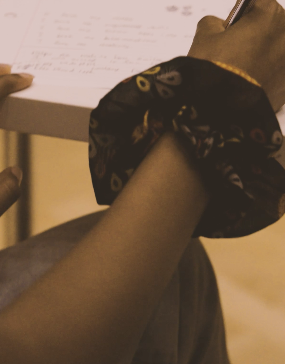 A young woman's hand writing on a page.